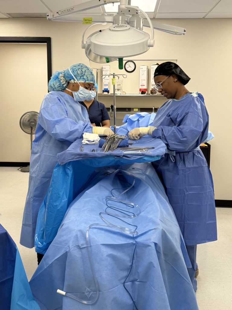 Surgical tech students draping a patient manikin in the operatory lab
