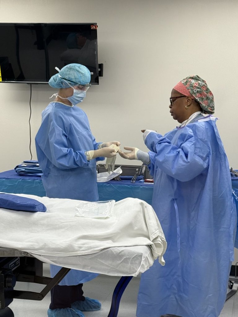 Surgical tech students practicing gowning and gloving